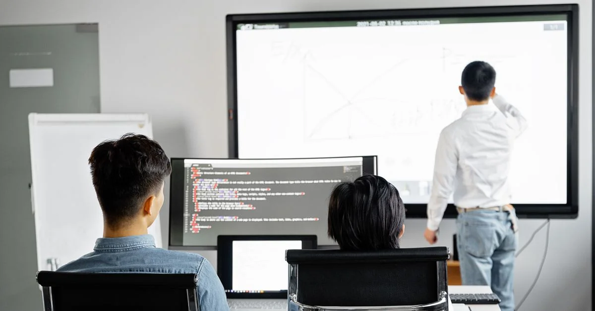 Équipe réalisant une présentation commerciale avec technologie dans un cadre de bureau moderne.