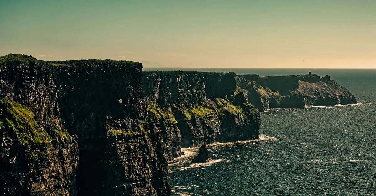 Vue à couper le souffle des falaises de Moher en Irlande sous un ciel lumineux.