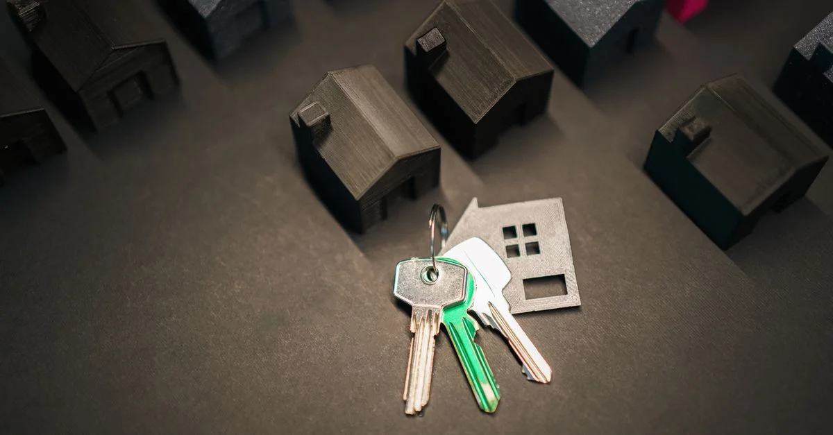 Les modèles de maisons miniatures et les clés symbolisent l'investissement immobilier et le marché du logement.