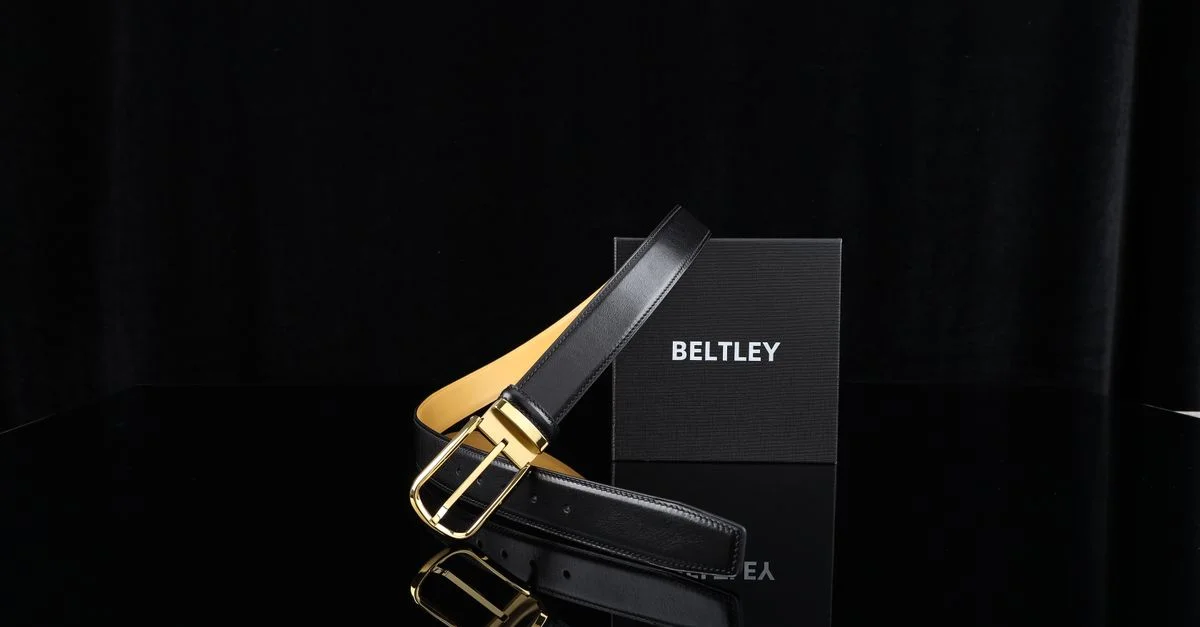 Ceinture élégante en cuir noir avec boucle dorée, présentée dans un coffret raffiné.